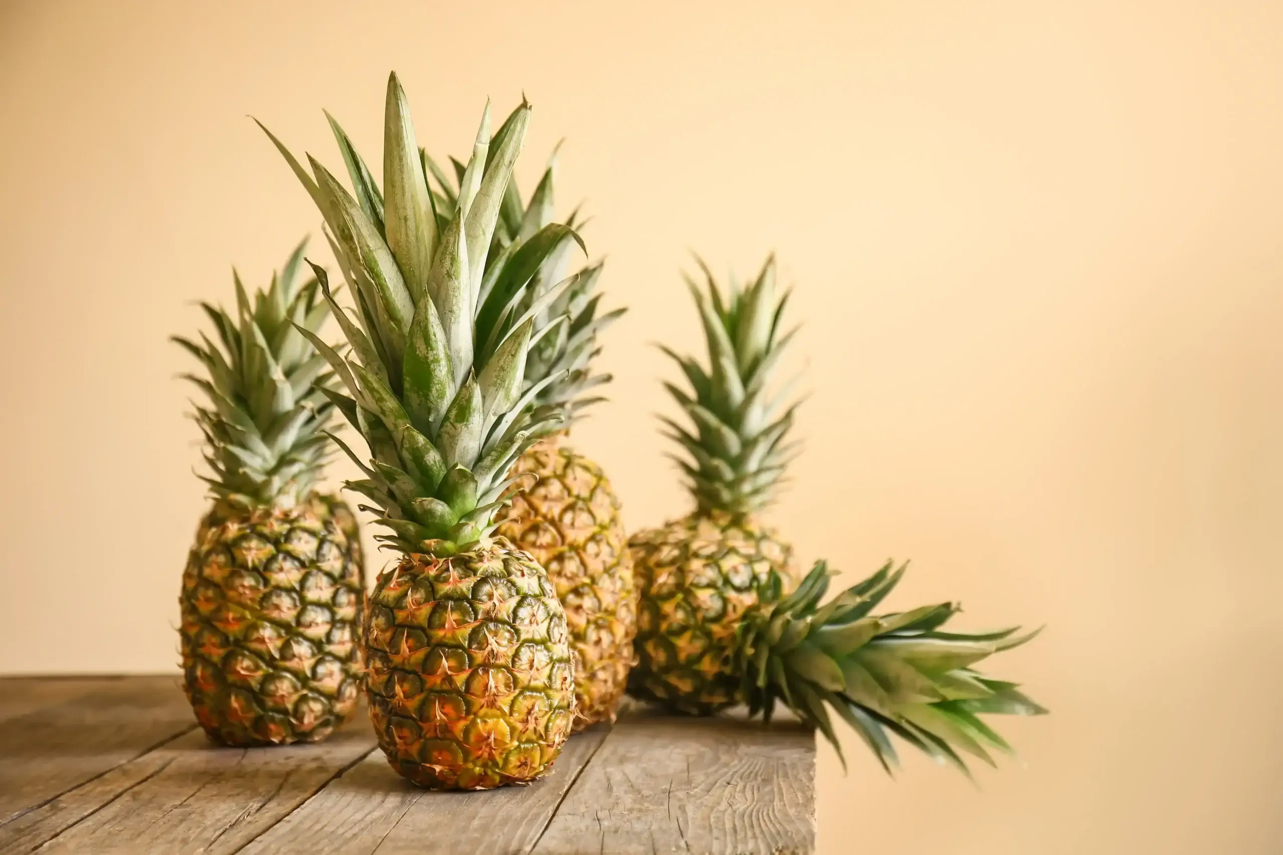 Plusieurs ananas disposés sur une table en bois
