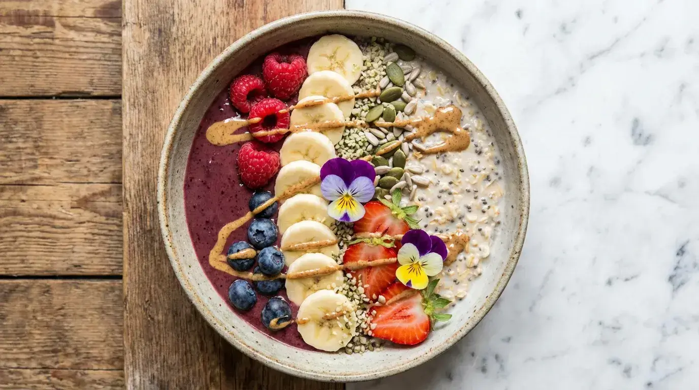 Smoothie bowl vue de dessus avec tranches de banane fruit, framboises, myrtilles, fraises, graines de chia, flocons d'avoine et beurre de cacahuète — petit-déjeuner sain et équilibré