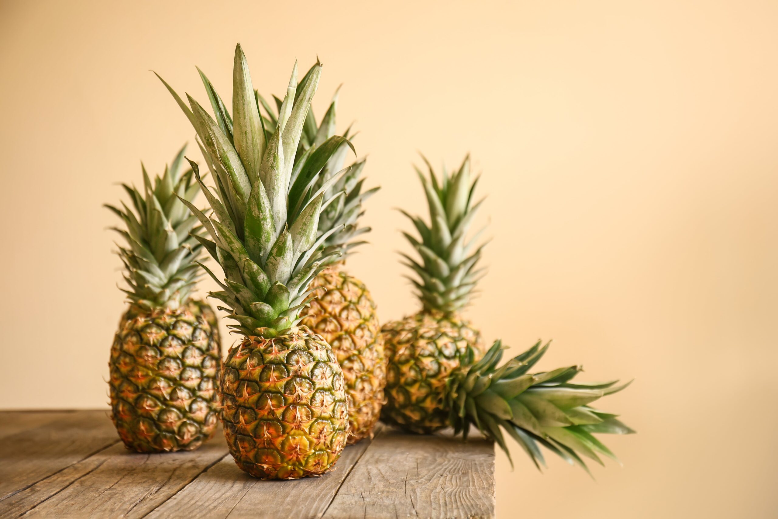 Ananas sur une table en bois sur fond de couleur