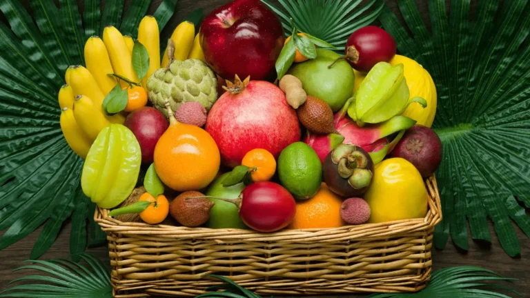 un panier en osier rempli de fruits tropicaux tels que des bananes, des grenades, des litchis et des caramboles, entouré de grandes.
