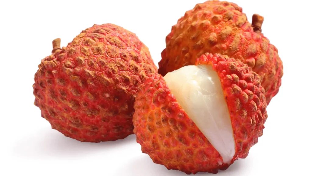 Litchis avec leur coque rouge texturée, l'un étant ouvert pour montrer sa chair blanche juteuse.