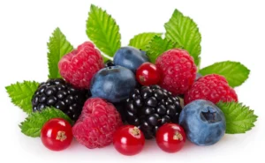 Mélange de fruits rouges, framboises, myrtilles, mûres et groseilles sur fond blanc, avec des feuilles vertes.