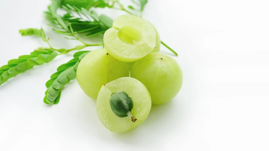 fruits en e-Embilic coupées et entières, avec des feuilles vertes en arrière-plan.