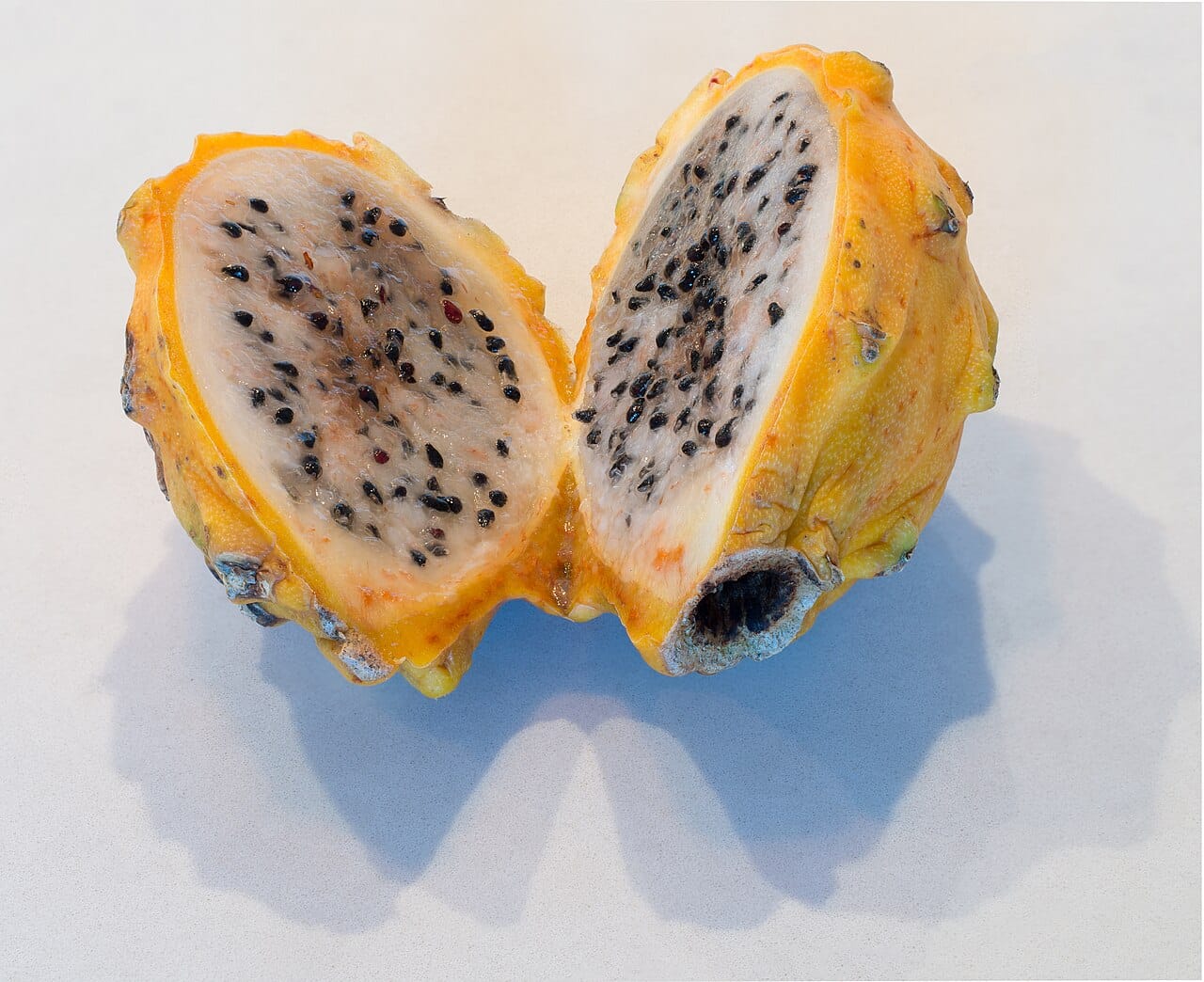 Fruit du dragon : vertus et conseils santé 2 Fruit du dragon jaune coupé en deux, chair blanche piquetée de graines noires