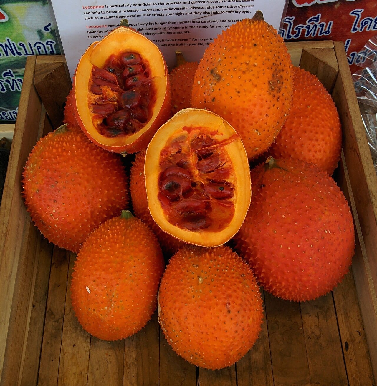 Gac Fruit : Top 7 Bienfaits Nutritionnels Étonnants du Superfruit Asiatique 2 Fruits de gac entiers et coupés révélant leur chair rouge vif