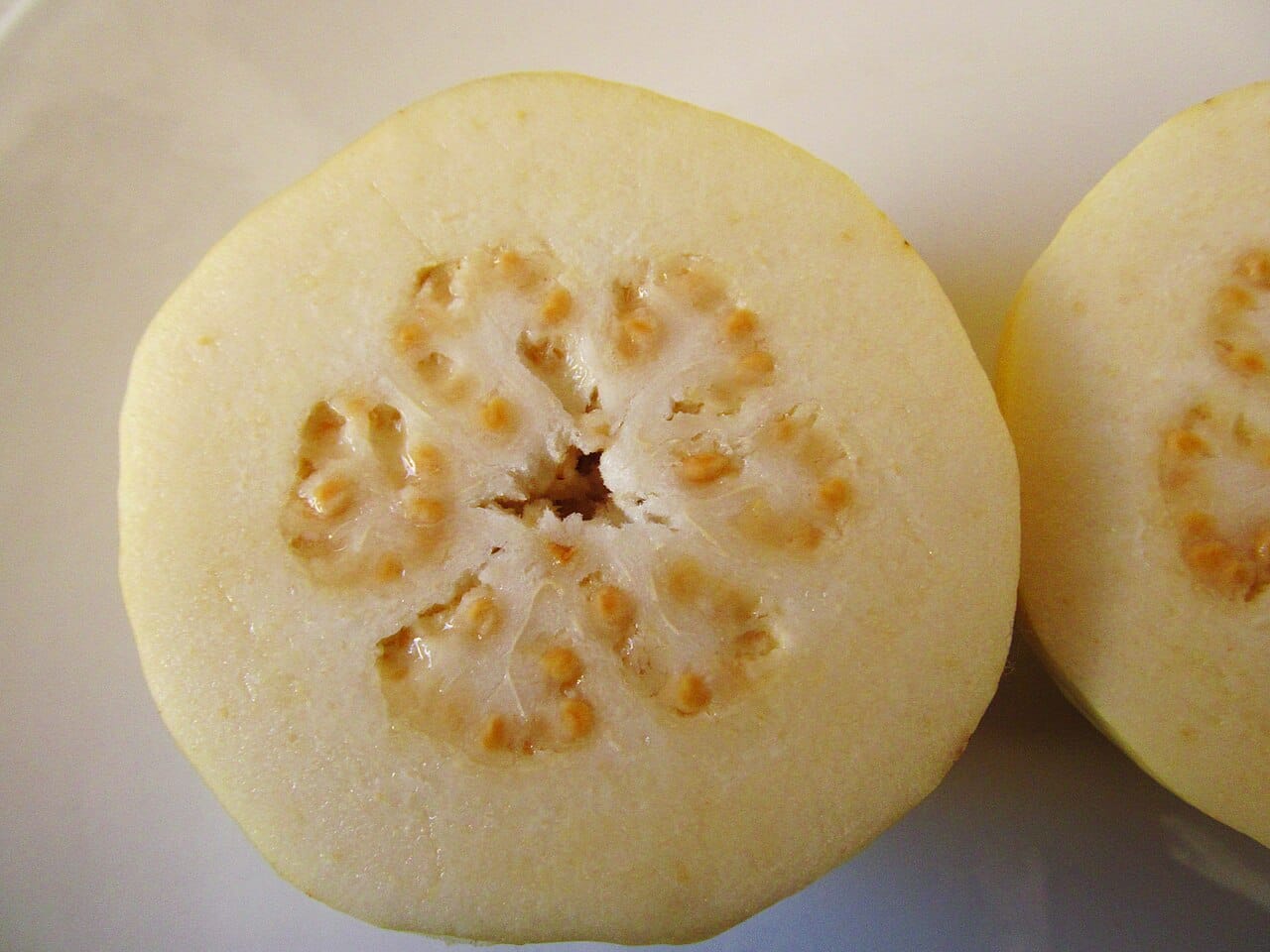 Goyave fruit : 3 bienfaits puissants et astuces pour la consommer 2 Goyave coupée en deux montrant sa chair claire parsemée de petites graines