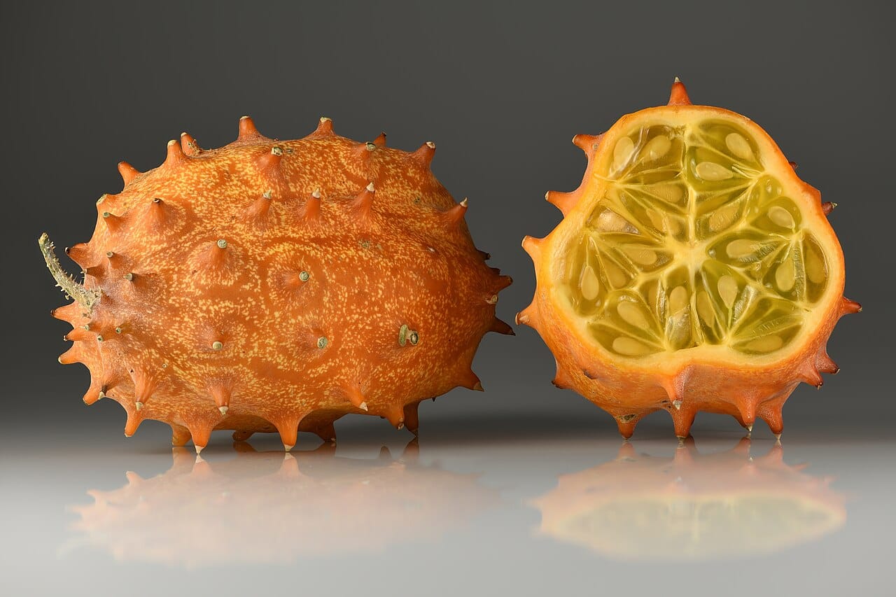 Kiwano fruit : un trésor exotique aux bienfaits santé 2 Kiwano ou melon à cornes entier et en coupe, peau orange épineuse et chair verte gélifiée